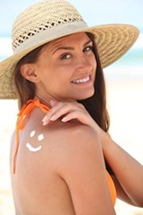 woman-with-sunscreen-on-the-beach-wearing-a-hat-xs